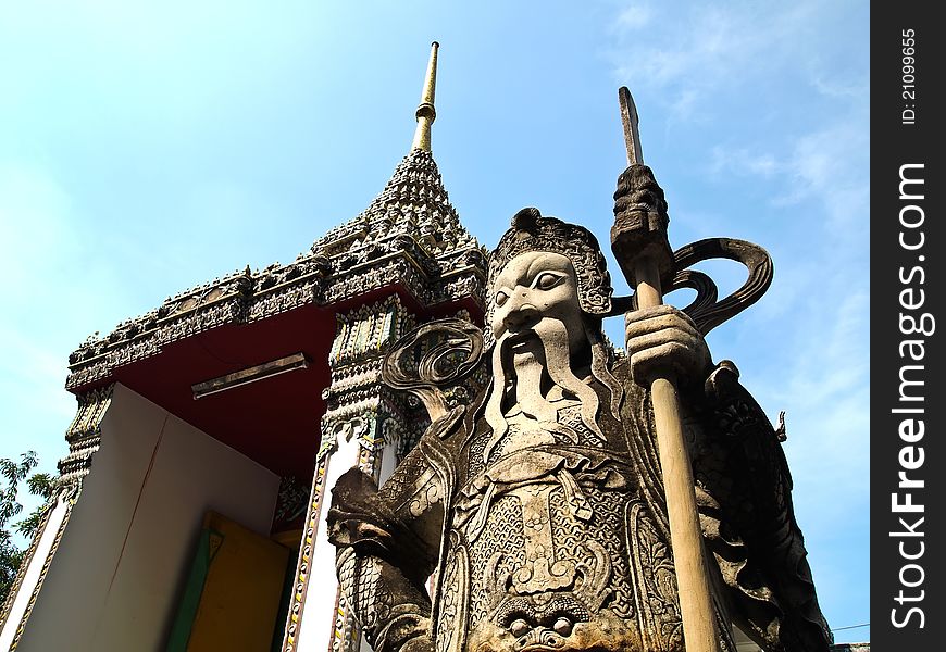 The stone Giant Guard at Wat Pho, Bangkok - Thailand with Blue sky on the background (vertical). The stone Giant Guard at Wat Pho, Bangkok - Thailand with Blue sky on the background (vertical)