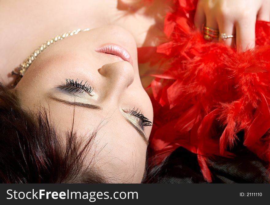 Woman with plumes. She is lying on bed. Woman with plumes. She is lying on bed.