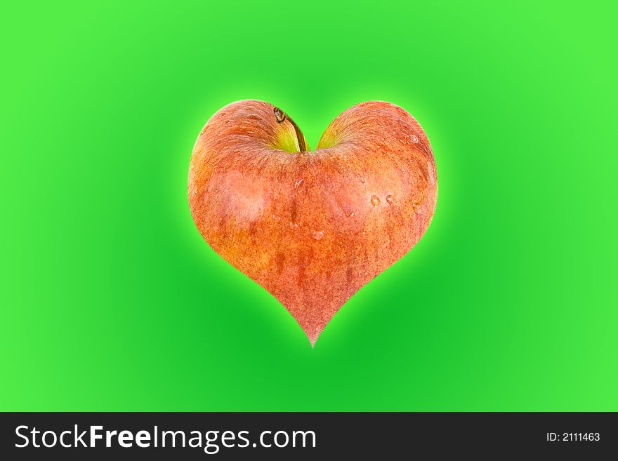 Heart shaped apple with a green background