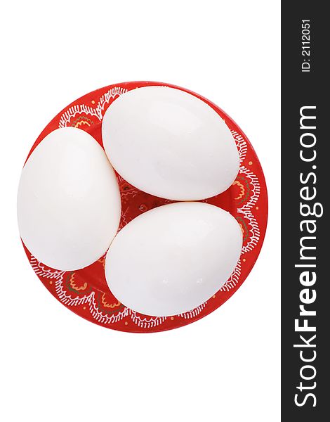 Thrree white eggs on a painted red plate. Thrree white eggs on a painted red plate.