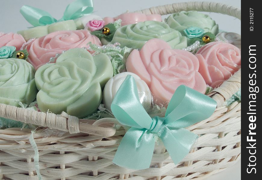 Some rose and pastel soaps in a basket. Some rose and pastel soaps in a basket