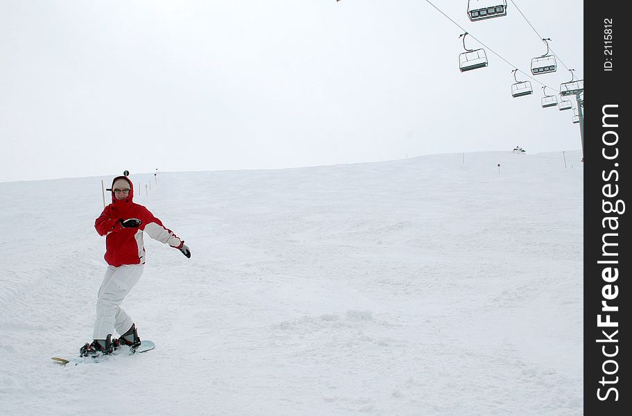 A snowboarding woman on a skislope having fun.