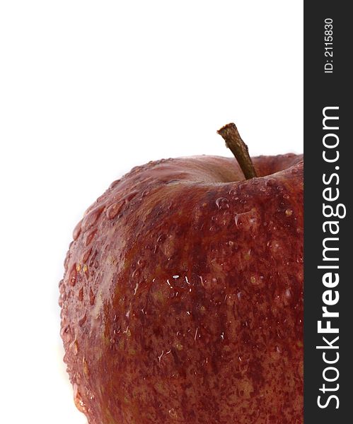 A delicious red apple with waterdrops over white background. A delicious red apple with waterdrops over white background.