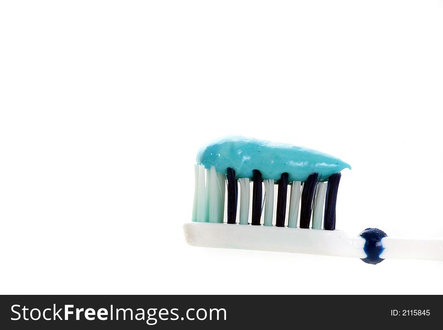 Closeup of a toothbrush with toothpaste in blue over white. Closeup of a toothbrush with toothpaste in blue over white.