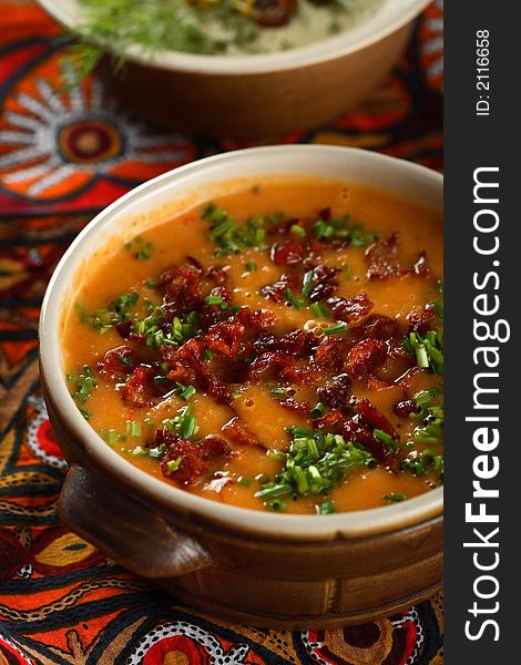 Creamy potatoes soup with red pepper and chives