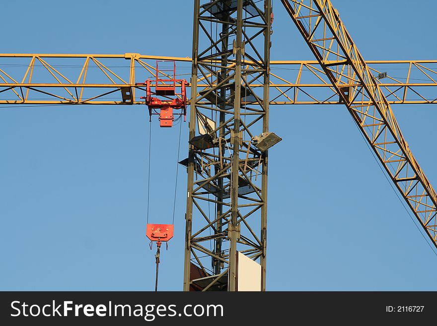 Criss crossing cranes on blue sky