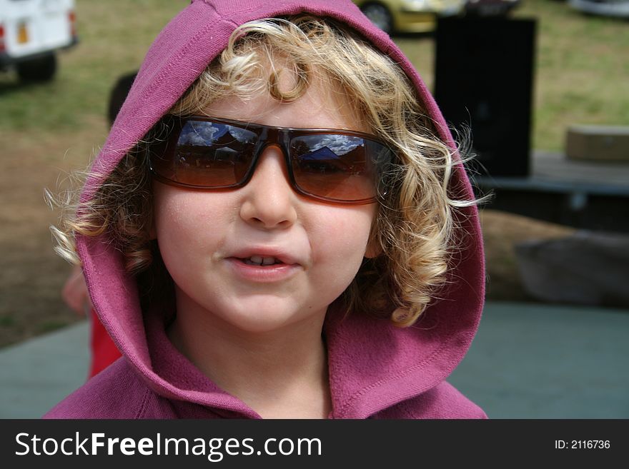 Little blond curly hair girl wearing sun glasses