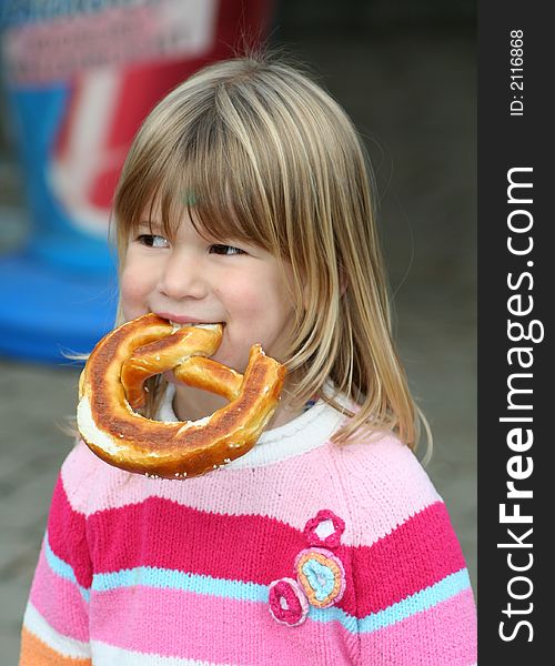 Little girl eating a piece of bread with her hands