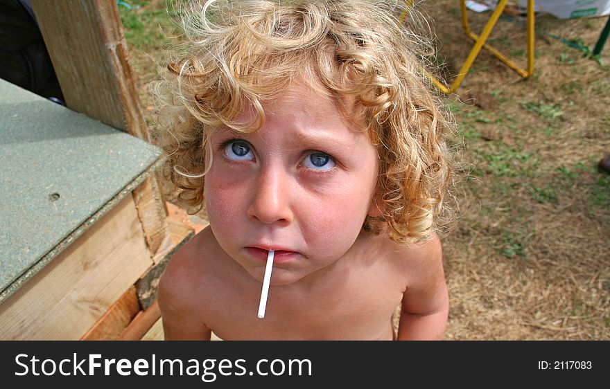 Little girl sucking her lolly and looking up. Little girl sucking her lolly and looking up