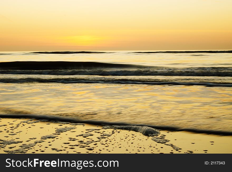 Ocean background (photo taken with slow shutterspeed) in golden colors