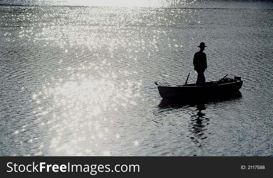 Silhouette of fisherman in boat