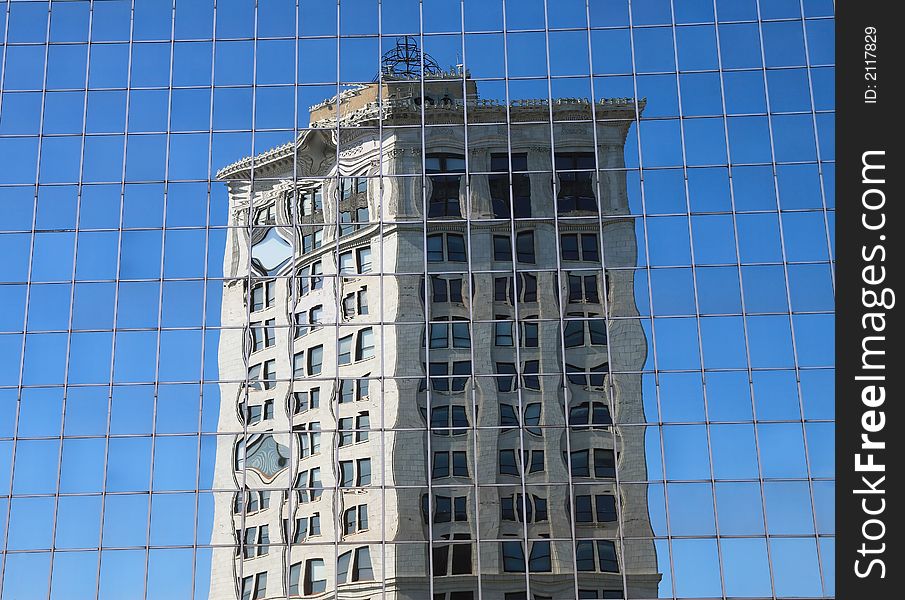 Reflection of older office structure in the windows of more contemporary building. Reflection of older office structure in the windows of more contemporary building
