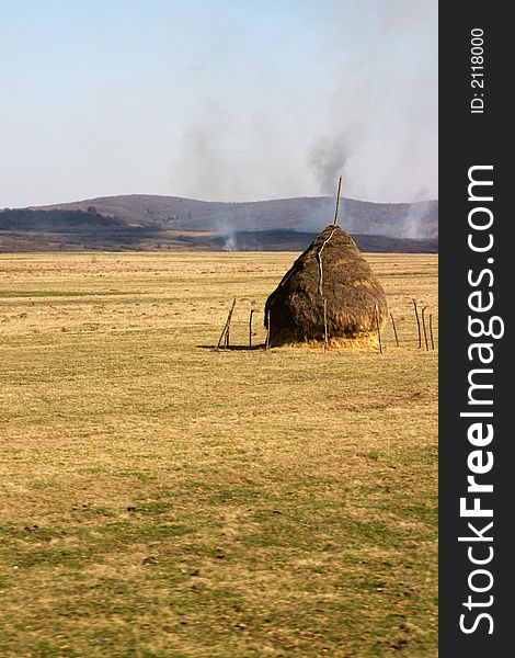 Burning field with single pack of grass in the middle of empty field. Burning field with single pack of grass in the middle of empty field