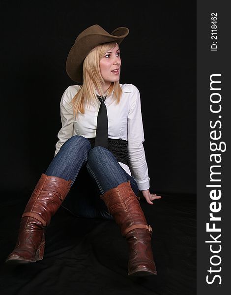 Beautiful blonde cowgirl in studio with cowboy hat