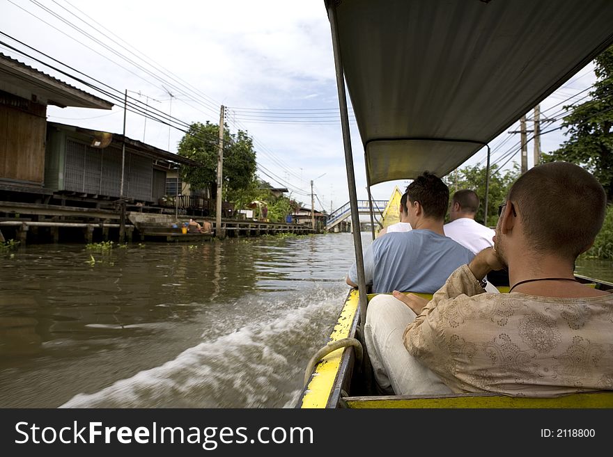 Tourists traveling in boats in the area of Thailand where there is no roads just channels.