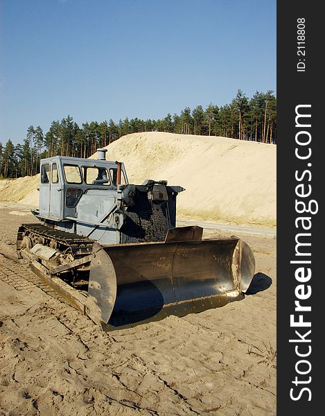 A excavator and forest in background