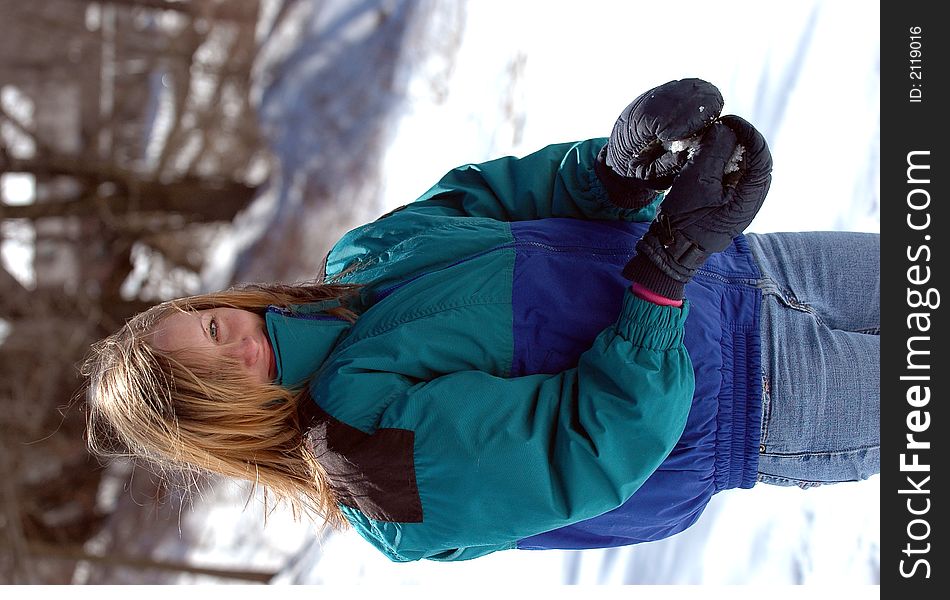 A teenage girl holding snow ball with a sly grin. A teenage girl holding snow ball with a sly grin