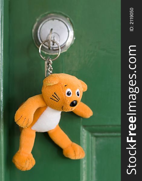 A teddy bear keyring in a lock waiting to open the door. A teddy bear keyring in a lock waiting to open the door.