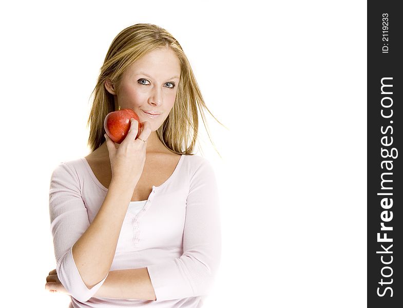 A blond girl is smiling and holding a red apple. A blond girl is smiling and holding a red apple