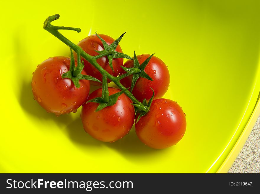 freshly washed tomatoes in a yellow bowl