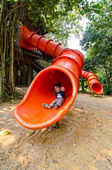 Happy Toddler Pre Schooler Sliding Down Red Slide Royalty Free Stock Photo