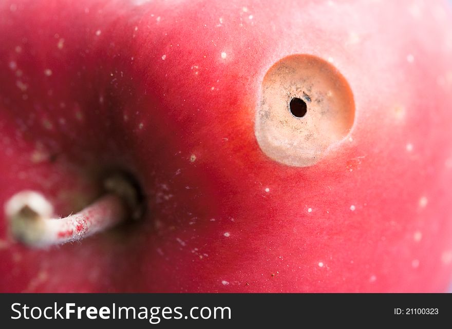 Close up of a red apple with a hole