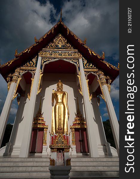 Golden stand big Buddha at front of Thai church in temple. Golden stand big Buddha at front of Thai church in temple.