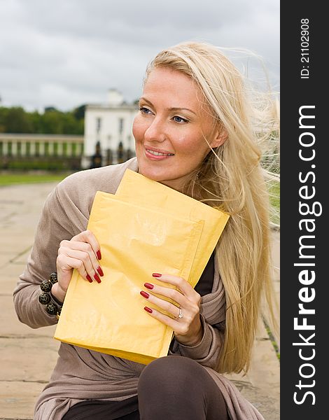 A young beautiful blond woman holding envelopes