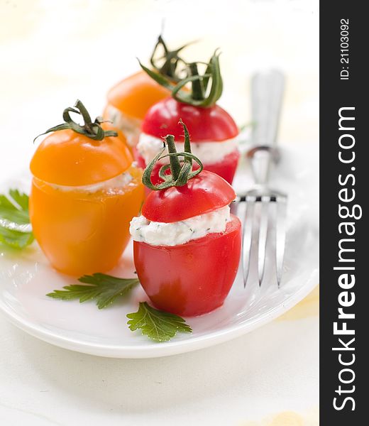 Red and yellow tomatoes stuffed with cottage cheese. Selective focus