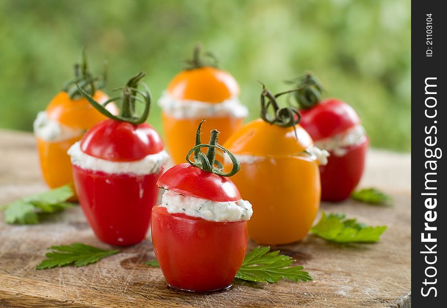 Red and yellow tomatoes stuffed with cottage cheese. Selective focus. Red and yellow tomatoes stuffed with cottage cheese. Selective focus