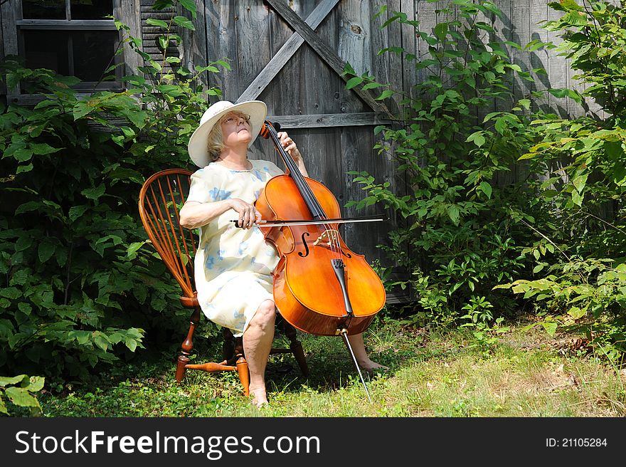Female cellist performing with her cello outside. Female cellist performing with her cello outside.