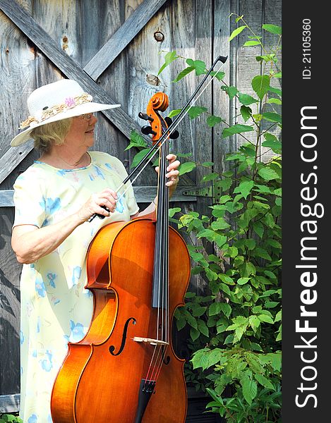 Female cellist performing with her cello outside. Female cellist performing with her cello outside.