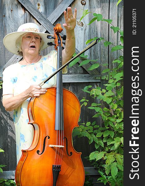 Female cellist performing with her cello outside. Female cellist performing with her cello outside.