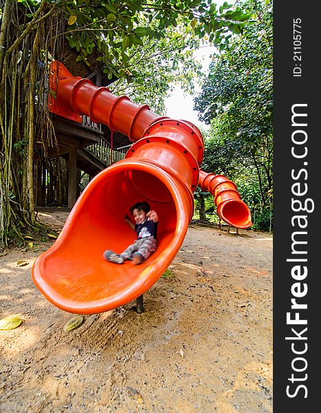 Happy Toddler Pre Schooler Sliding Down Red Slide