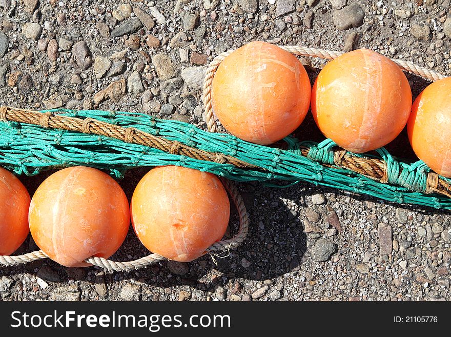 Six orange coloured fishing floats with ropes at harbour. Six orange coloured fishing floats with ropes at harbour