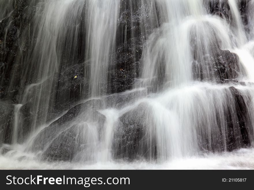 Close-up view of waterfall with use of slow shutter speed to create misty water effect. Close-up view of waterfall with use of slow shutter speed to create misty water effect