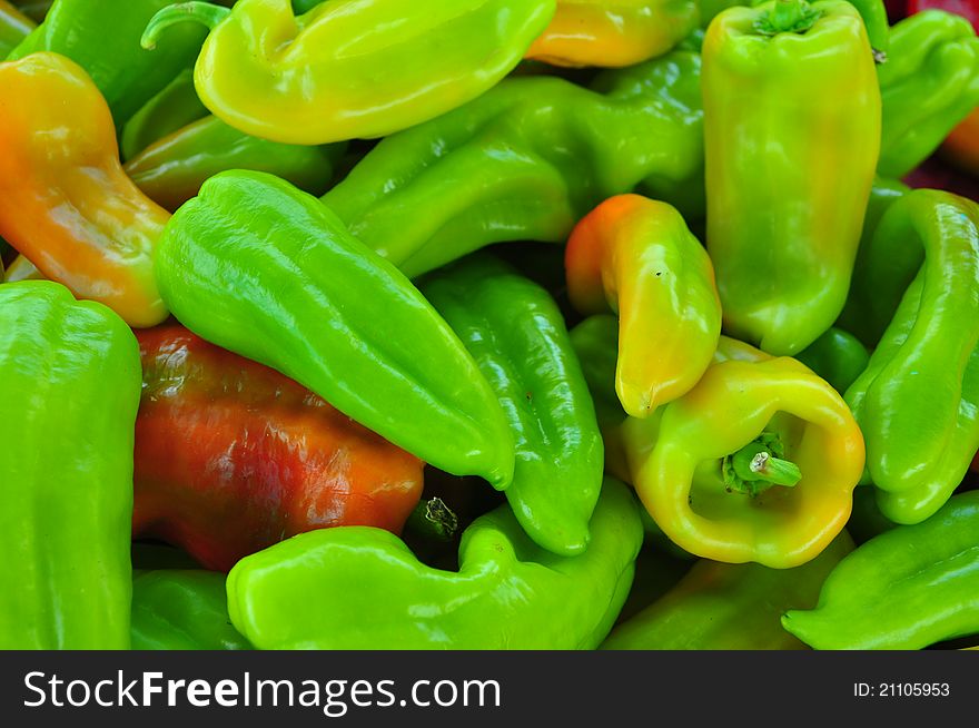 Red, green, and yellow peppers stacked