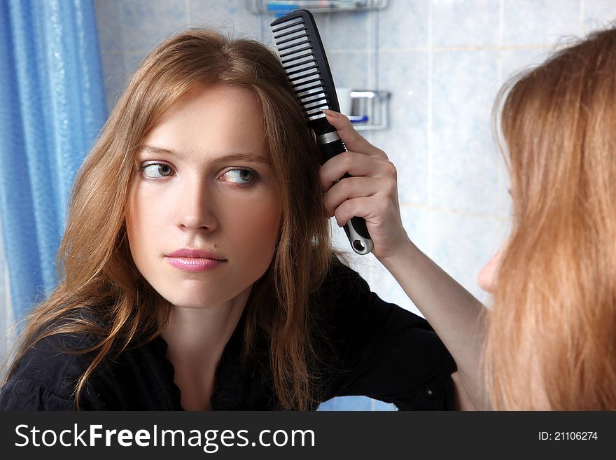 Young woman in bath at front of a mirror correcting hairs. Young woman in bath at front of a mirror correcting hairs