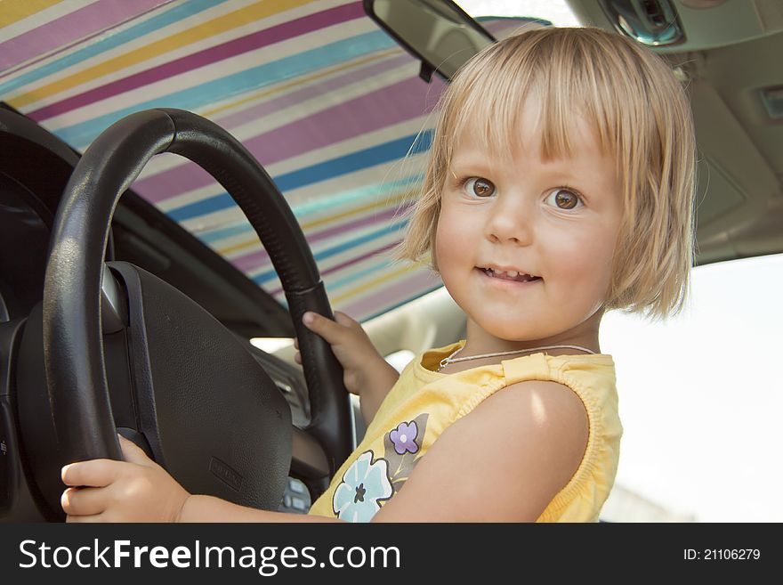 The joyful child holds for a car steering wheel. The joyful child holds for a car steering wheel