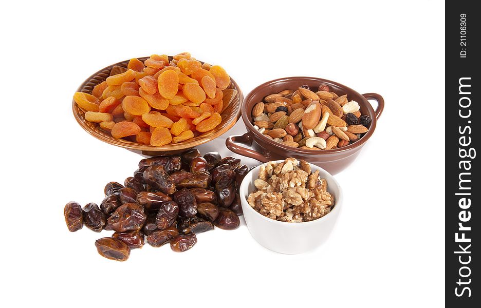 The dried apricots, nuts, raisin, dates lie in vases. The dried apricots, nuts, raisin, dates lie in vases