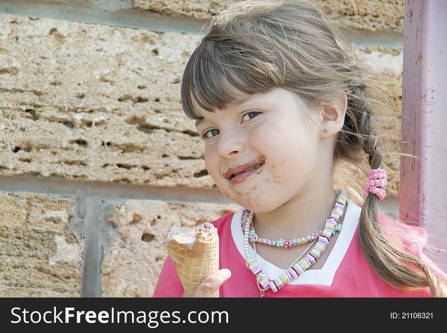 The soiled child holds ice-cream in a hand and artfully looks forward. The soiled child holds ice-cream in a hand and artfully looks forward