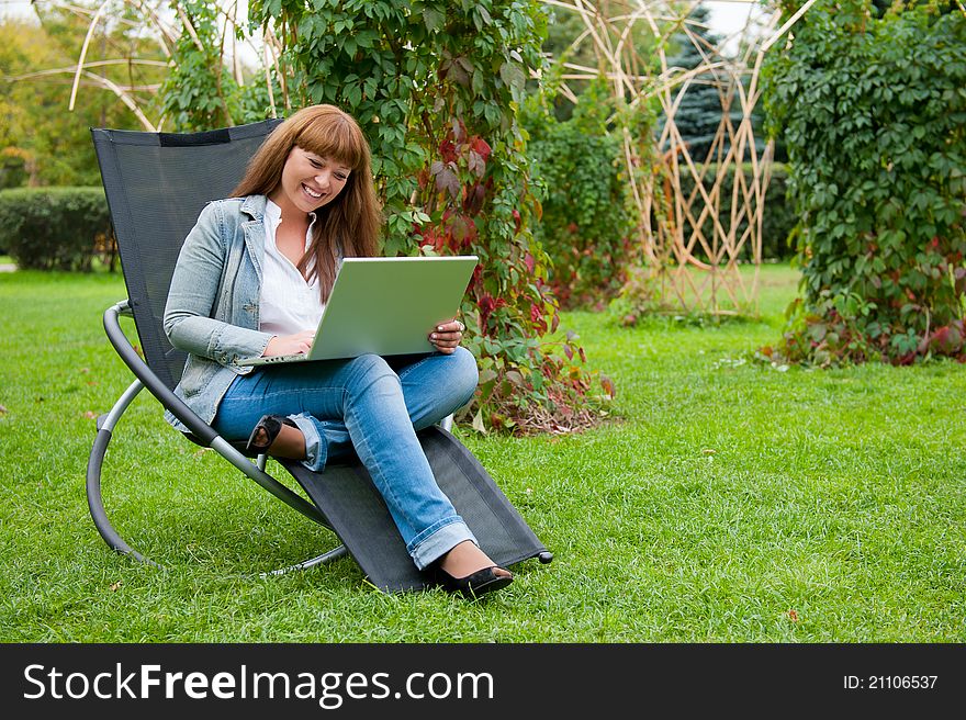 Young woman working on laptop in the park