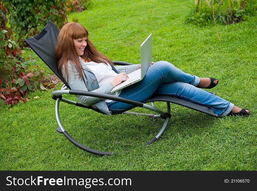 Young woman working on laptop in the park