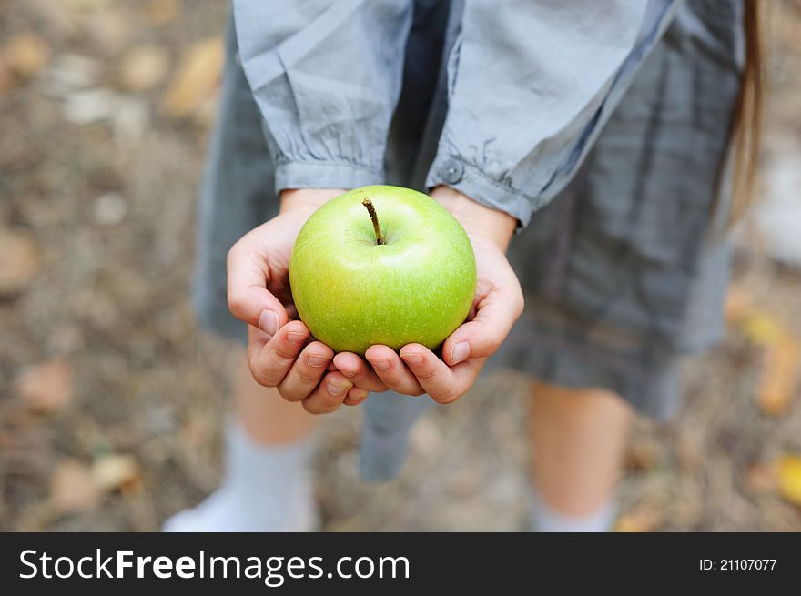 A green apple in little child's hands. A green apple in little child's hands