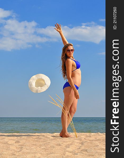 Girl in bikini toss up a straw hat on the beach. Girl in bikini toss up a straw hat on the beach