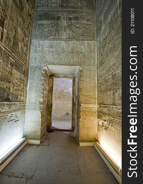 Corridor through an arched doorway in an ancient egyptian temple with hieroglyphic carvings. Corridor through an arched doorway in an ancient egyptian temple with hieroglyphic carvings