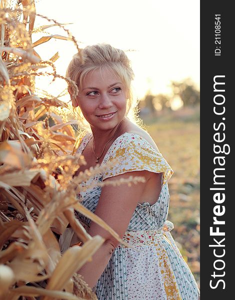 Young woman in corn haystack and sunset
