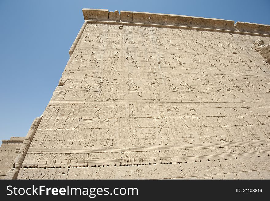 Hieroglyphic carvings on the exterior walls of an ancient egyptian temple. Hieroglyphic carvings on the exterior walls of an ancient egyptian temple