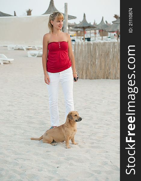 Young woman playing with her dog on the beach.