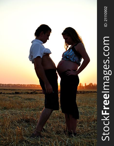 The pregnant girl and the guy are measured by stomachs